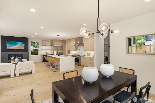 819 18th Ave W, Kirkland, WA 98033 - dining space with light wood finished floors, recessed lighting, beverage cooler, a chandelier, and a glass covered fireplace