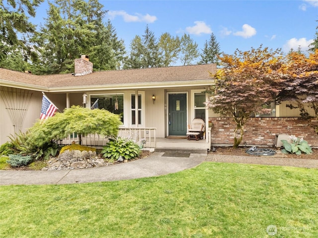 6908 254th St E, Graham, WA 98338 - ranch-style house featuring a porch, a chimney, a front yard, and brick siding