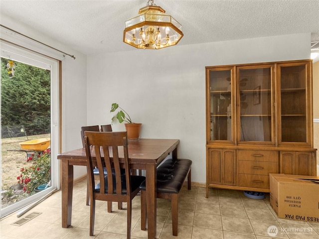 6908 254th St E, Graham, WA 98338 - dining area with a chandelier, light tile patterned floors, and a textured ceiling