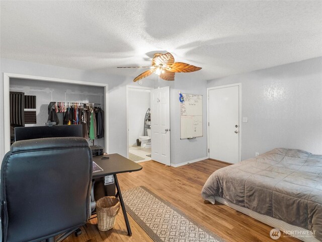 6908 254th St E, Graham, WA 98338 - bedroom featuring a closet, wood finished floors, a textured ceiling, a ceiling fan, and connected bathroom