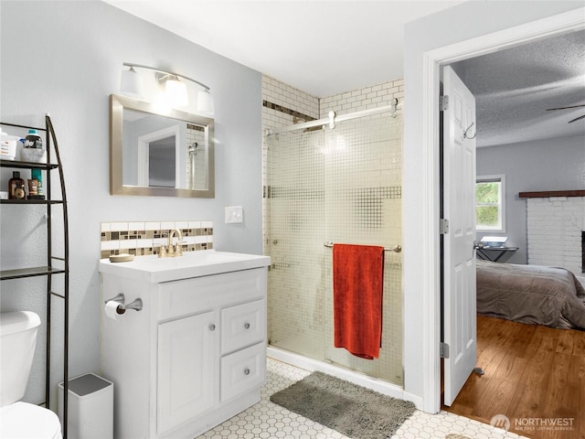 6908 254th St E, Graham, WA 98338 - full bath with connected bathroom, vanity, a stall shower, a brick fireplace, and a ceiling fan