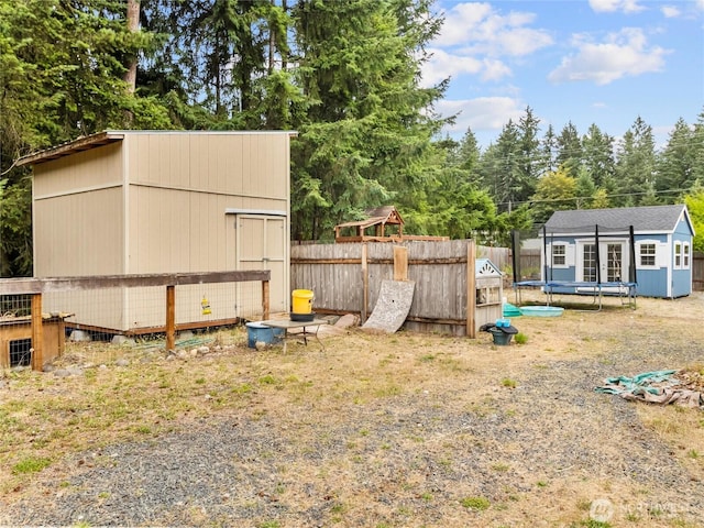 6908 254th St E, Graham, WA 98338 - view of yard featuring a shed, a trampoline, and view of scattered trees