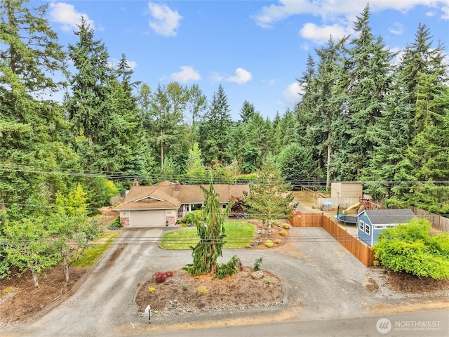 6908 254th St E, Graham, WA 98338 - view of front of property featuring driveway, a garage, and a view of trees