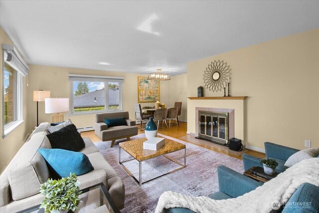 9237 24th Ave NW, Seattle, WA 98117 - living room with wood finished floors, a chandelier, and a baseboard radiator