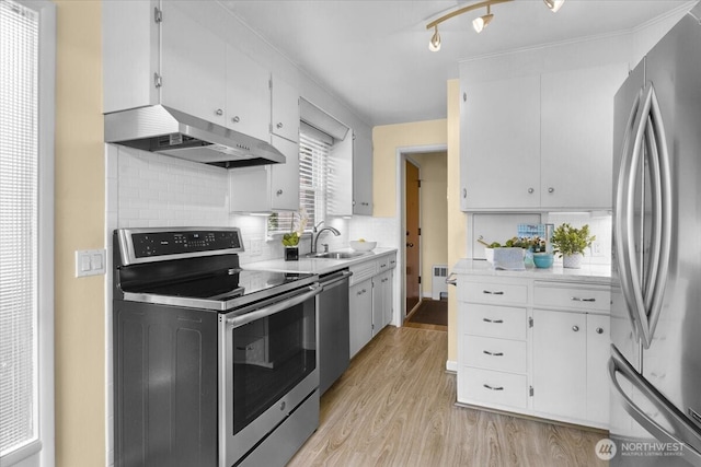 9237 24th Ave NW, Seattle, WA 98117 - kitchen featuring stainless steel appliances, under cabinet range hood, light wood finished floors, and light countertops