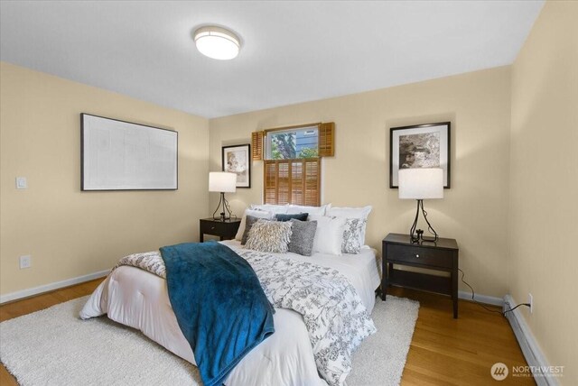 9237 24th Ave NW, Seattle, WA 98117 - bedroom featuring wood finished floors and a baseboard heating unit
