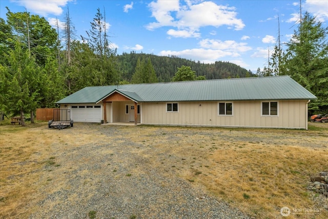 7609 Pressentin Ct, Concrete, WA 98237 - ranch-style house featuring a wooded view, a metal roof, a garage, driveway, and board and batten siding