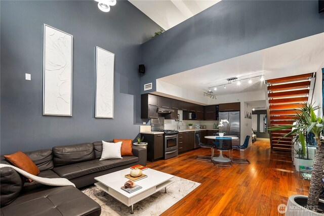 2911 2nd Ave Unit 120, Seattle, WA 98121 - living room with dark wood-type flooring, a high ceiling, and rail lighting