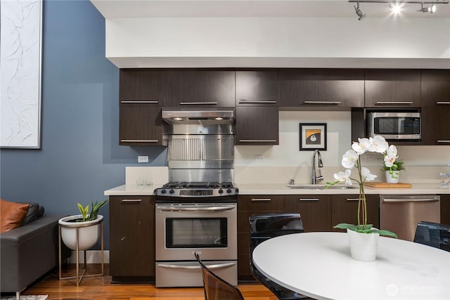 2911 2nd Ave Unit 120, Seattle, WA 98121 - kitchen featuring stainless steel appliances, extractor fan, light countertops, and dark brown cabinets