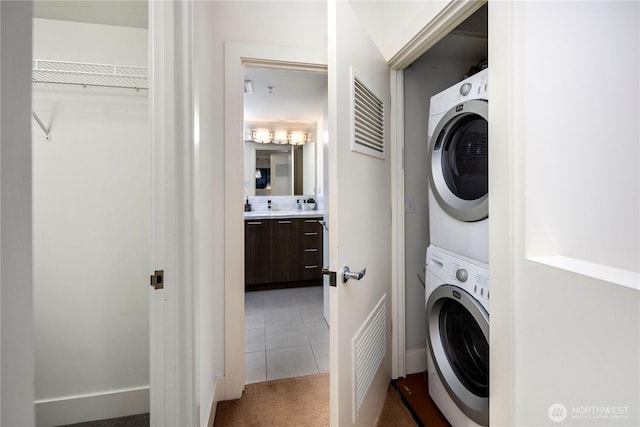 2911 2nd Ave Unit 120, Seattle, WA 98121 - laundry room featuring stacked washer / drying machine, tile patterned flooring, and carpet floors