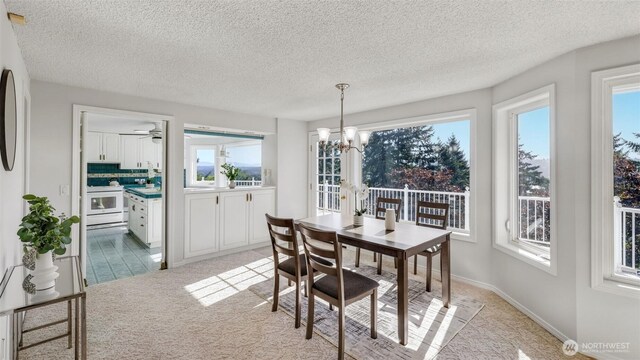 1517 126th Ave E, Edgewood, WA 98372 - dining room with light colored carpet, a chandelier, and a textured ceiling