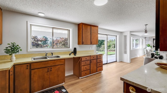 1517 126th Ave E, Edgewood, WA 98372 - kitchen with light wood finished floors, light countertops, brown cabinets, and a textured ceiling