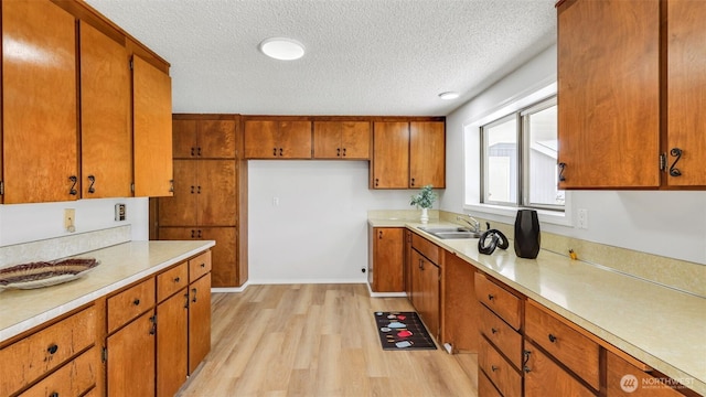 1517 126th Ave E, Edgewood, WA 98372 - kitchen with a textured ceiling, brown cabinetry, light wood-style flooring, and light countertops