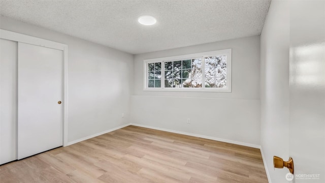 1517 126th Ave E, Edgewood, WA 98372 - unfurnished bedroom with a textured ceiling, wood finished floors, and a closet