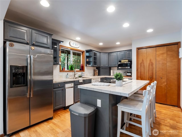 10723 105th Street Ct, Anderson Island, WA 98303 - kitchen featuring stainless steel appliances, tile countertops, light wood finished floors, a center island, and recessed lighting