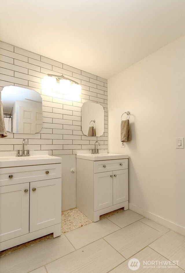 29851 12th Ave SW, Federal Way, WA 98023 - bathroom featuring two vanities, decorative backsplash, tile walls, and tile patterned flooring
