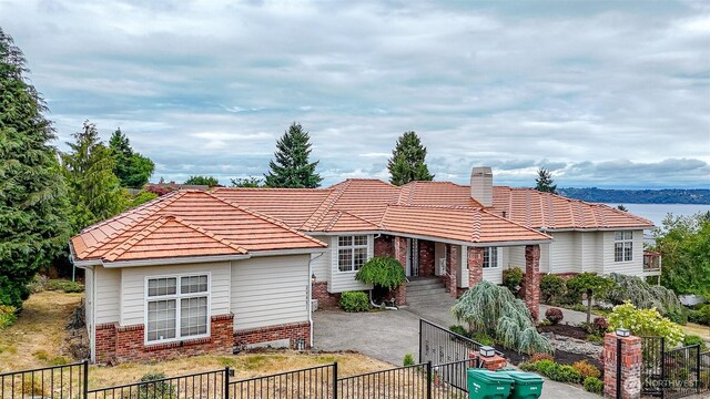 29851 12th Ave SW, Federal Way, WA 98023 - view of front of home with brick siding, a fenced backyard, a tile roof, a chimney, and a gate
