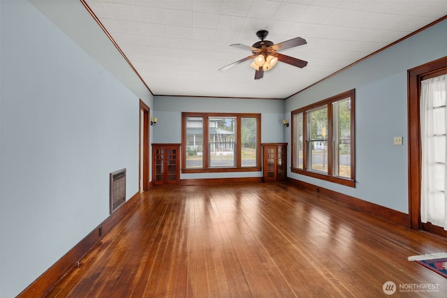802 May St, Raymond, WA 98577 - unfurnished living room featuring wood-type flooring, ceiling fan, and ornamental molding