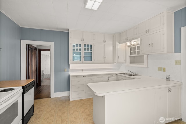 802 May St, Raymond, WA 98577 - kitchen featuring black dishwasher, light countertops, white cabinets, crown molding, and a peninsula