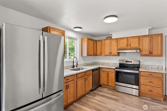 110 Cedar Crest Pl, Napavine, WA 98532 - kitchen with appliances with stainless steel finishes, under cabinet range hood, brown cabinetry, and light wood-type flooring