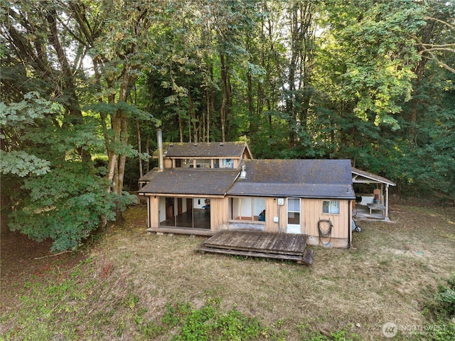 9744 Cascade Loop NE, Olympia, WA 98516 - rear view of house featuring a shingled roof, a forest view, a wooden deck, and a lawn