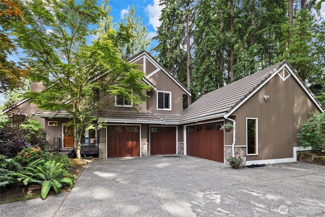 18608 SE 58th St, Issaquah, WA 98027 - view of front of house featuring asphalt driveway, stone siding, a tiled roof, and a garage
