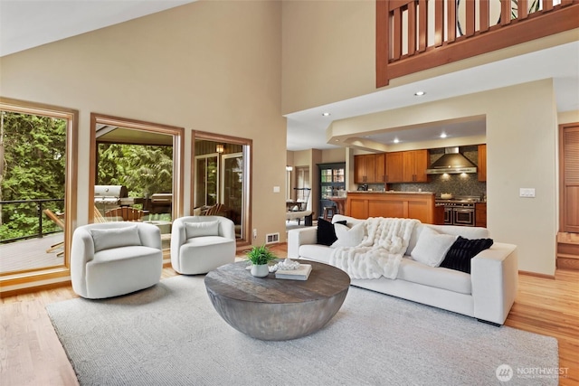 18608 SE 58th St, Issaquah, WA 98027 - living area featuring light wood-style flooring, a towering ceiling, and recessed lighting