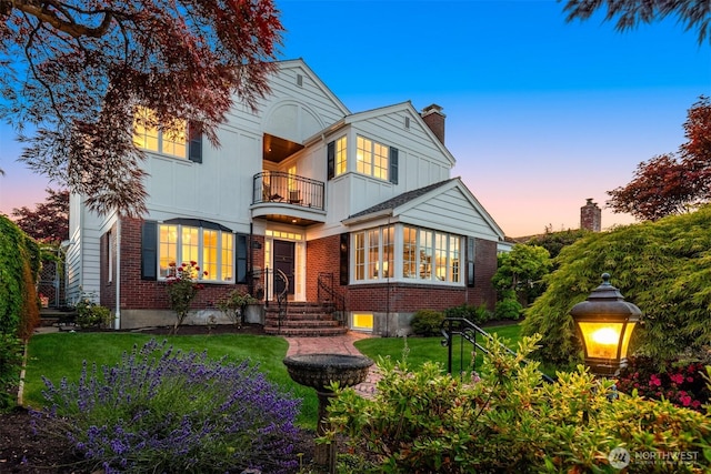 1915 35th Ave W, Seattle, WA 98199 - view of front of home featuring a balcony, brick siding, board and batten siding, and a chimney
