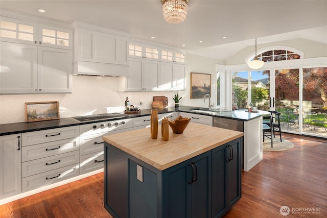 1915 35th Ave W, Seattle, WA 98199 - kitchen featuring butcher block counters, cooktop, dark wood-style flooring, white cabinets, and a peninsula