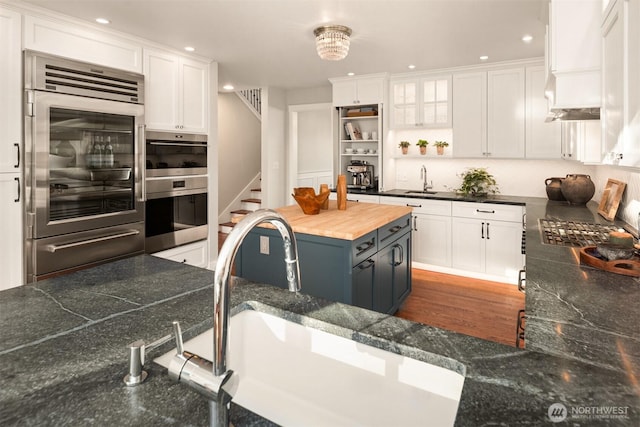 1915 35th Ave W, Seattle, WA 98199 - kitchen with appliances with stainless steel finishes, white cabinetry, open shelves, butcher block countertops, and recessed lighting