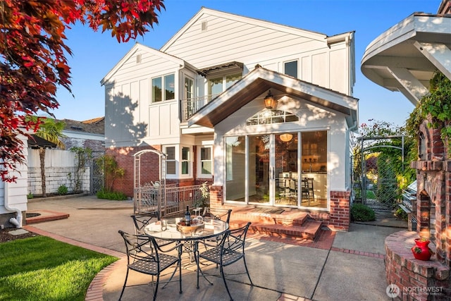 1915 35th Ave W, Seattle, WA 98199 - rear view of house with brick siding, board and batten siding, a patio, and a balcony