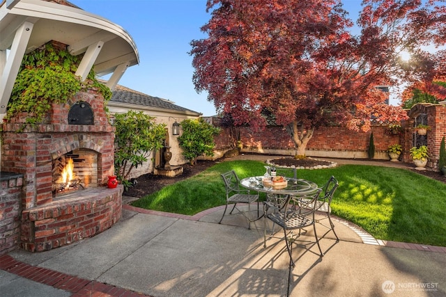 1915 35th Ave W, Seattle, WA 98199 - fenced backyard featuring an outdoor brick fireplace, a patio, and outdoor dining area