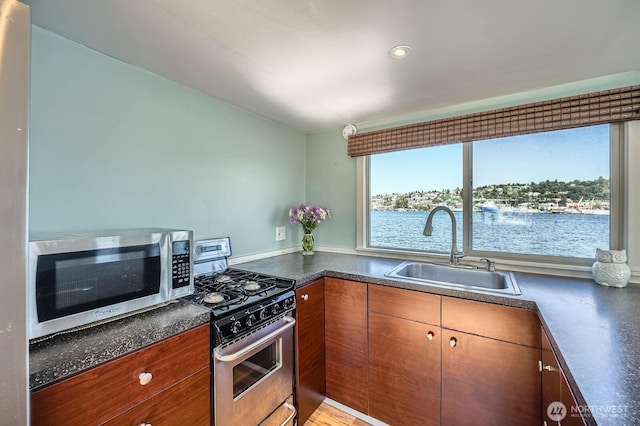 1818 Westlake Ave N Unit D-33, Seattle, WA 98109 - kitchen with stainless steel appliances, dark countertops, and brown cabinetry
