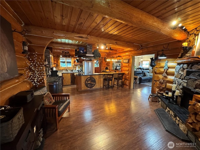 8 Iris Ln, Twisp, WA 98856 - living area featuring log walls, dark wood-type flooring, a wooden ceiling with exposed beams, a fireplace, and arched walkways