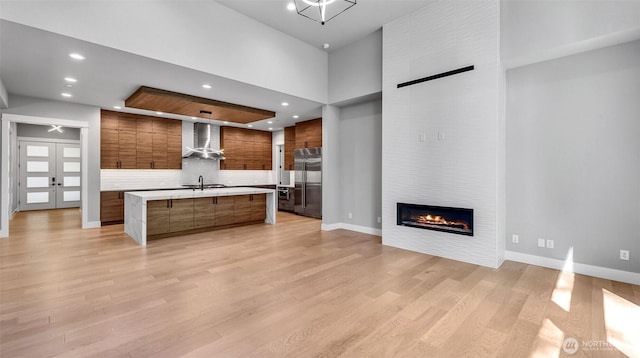 1542 213th Ct NE, Sammamish, WA 98074 - kitchen featuring stainless steel built in fridge, wall chimney exhaust hood, modern cabinets, open floor plan, and light countertops