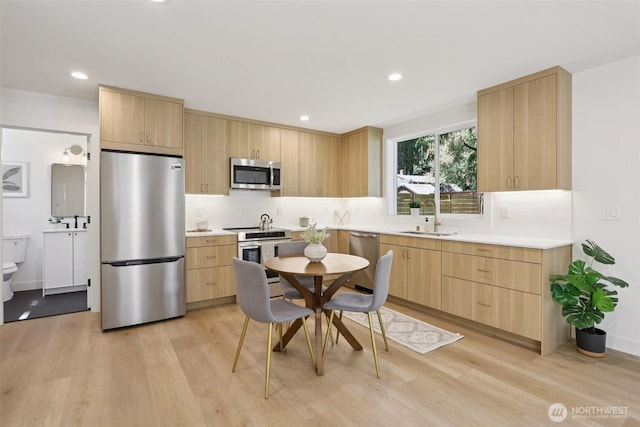 11737 38th Ave NE Unit B, Seattle, WA 98125 - kitchen with appliances with stainless steel finishes, light brown cabinetry, light wood-style floors, tasteful backsplash, and recessed lighting
