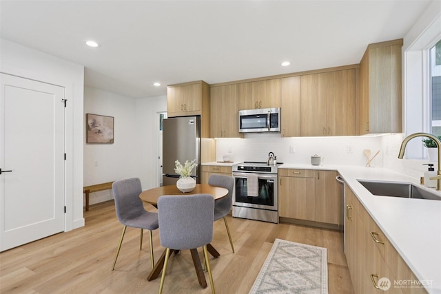 11737 38th Ave NE Unit B, Seattle, WA 98125 - kitchen featuring stainless steel appliances, light brown cabinetry, decorative backsplash, light wood-style flooring, and light countertops