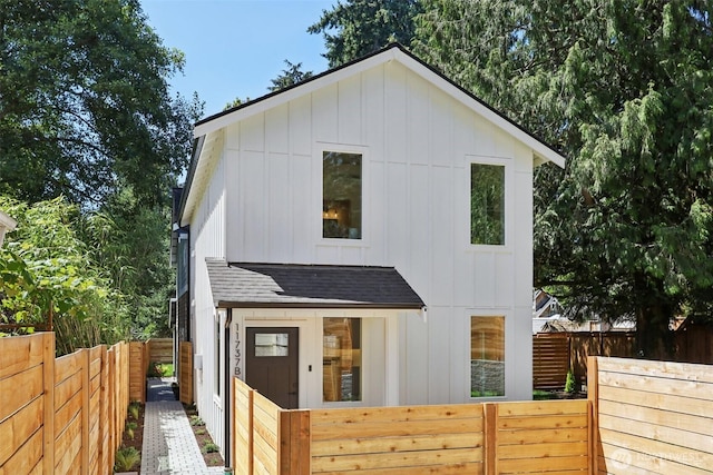 11737 38th Ave NE Unit B, Seattle, WA 98125 - view of front facade featuring a shingled roof, board and batten siding, and a fenced backyard