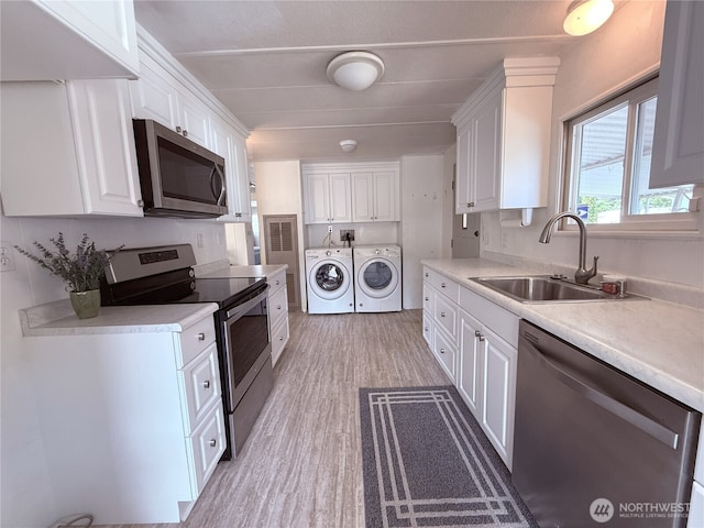 1200 Lincoln St Unit 418, Bellingham, WA 98229 - kitchen with appliances with stainless steel finishes, washing machine and dryer, white cabinets, and light wood-type flooring