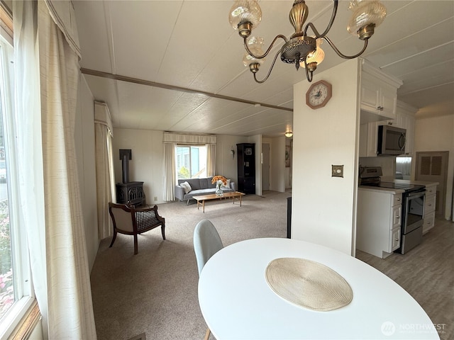 1200 Lincoln St Unit 418, Bellingham, WA 98229 - dining area featuring a wood stove, a chandelier, and light colored carpet