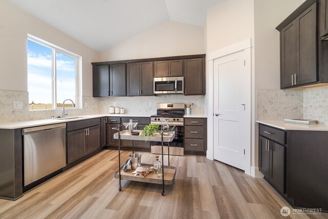 5763 S Sherri Lea Rd, Spokane, WA 99224 - kitchen with appliances with stainless steel finishes, backsplash, light wood-type flooring, light countertops, and high vaulted ceiling