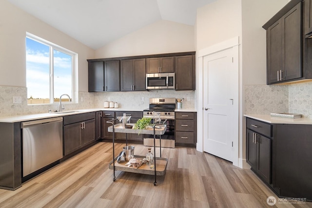 5819 S Sherri Lea Rd, Spokane, WA 99224 - kitchen featuring stainless steel appliances, decorative backsplash, light wood-style flooring, light countertops, and high vaulted ceiling