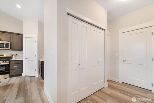 5819 S Sherri Lea Rd, Spokane, WA 99224 - kitchen with appliances with stainless steel finishes, light wood-type flooring, light countertops, dark brown cabinets, and decorative backsplash