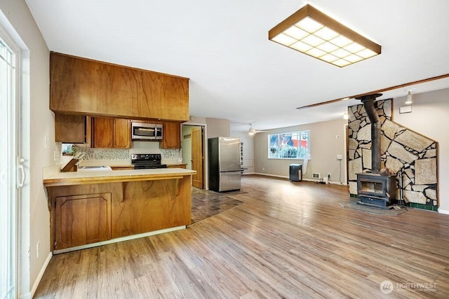636 Nevil Rd, Winlock, WA 98596 - kitchen with appliances with stainless steel finishes, brown cabinetry, open floor plan, light wood-style floors, and light countertops