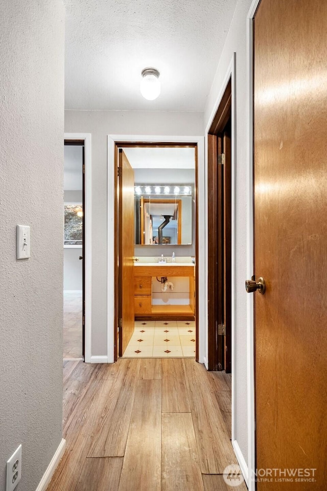 636 Nevil Rd, Winlock, WA 98596 - hallway with light wood finished floors, a textured ceiling, and a textured wall