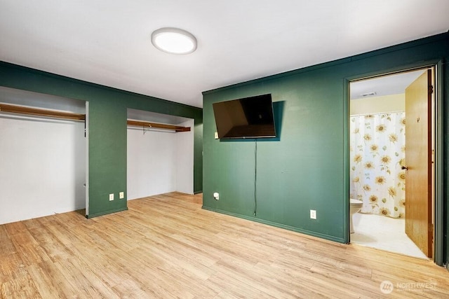 636 Nevil Rd, Winlock, WA 98596 - unfurnished bedroom with wood finished floors, multiple closets, and ensuite bathroom