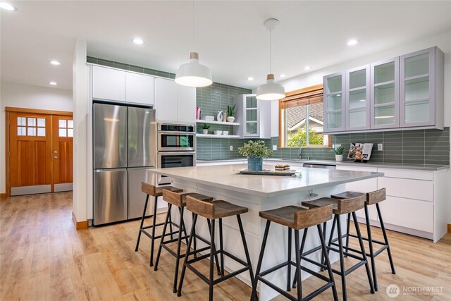 9002 Gleneagle Dr, Blaine, WA 98230 - kitchen with appliances with stainless steel finishes, tasteful backsplash, a breakfast bar area, and recessed lighting