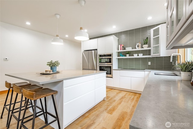 9002 Gleneagle Dr, Blaine, WA 98230 - kitchen with stainless steel appliances, modern cabinets, open shelves, a kitchen island, and tasteful backsplash