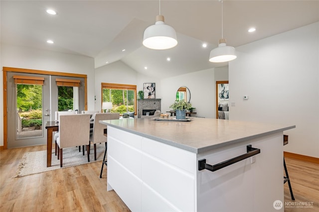 9002 Gleneagle Dr, Blaine, WA 98230 - kitchen featuring white cabinets, vaulted ceiling, recessed lighting, a center island, and light wood-style floors