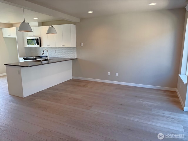 664 LOT25 W Kline Rd, Bellingham, WA 98226 - kitchen with stainless steel microwave, dark countertops, light wood-type flooring, backsplash, and recessed lighting